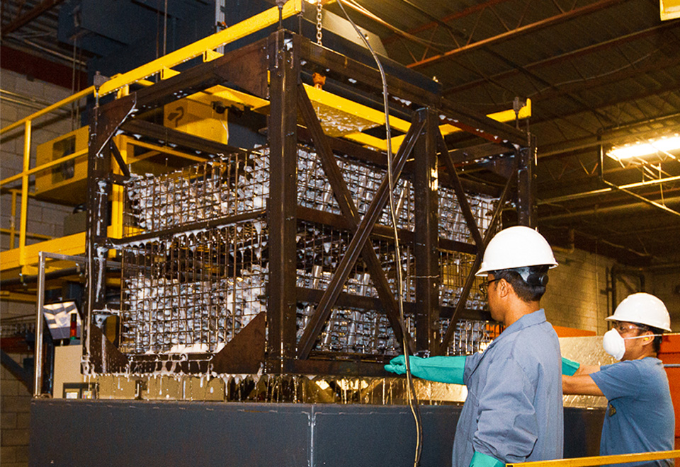 Close view of workers cooling down pieces during heat treatment